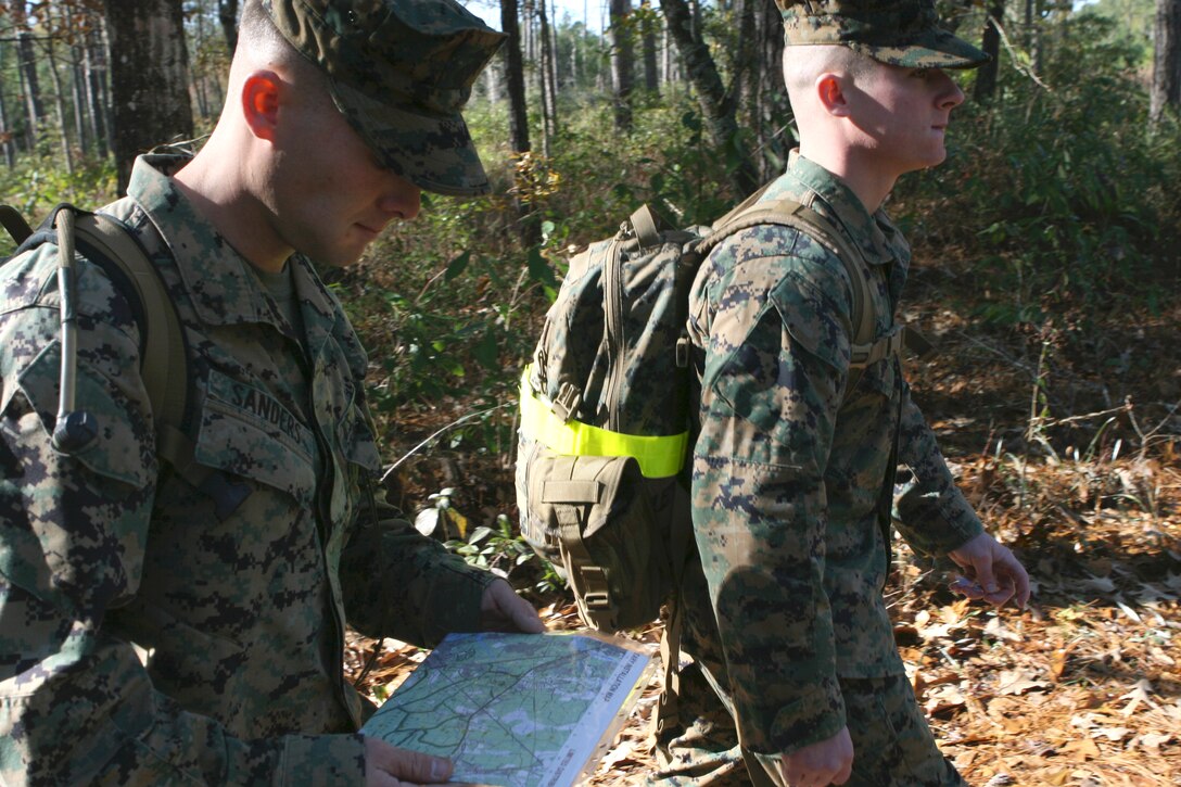 Lance Cpl. Marvin Sanders (left) and Lance Cpl. Nathan Conway, with 1st Battalion, 6th Marine Regiment, 2nd Marine Division, walk along a trail during a land navigation course here, Dec. 3. The Marines honed their land navigational skills, which are necessary for future deployments, using basic instruments such as a map, compass, protractor, and a pen.