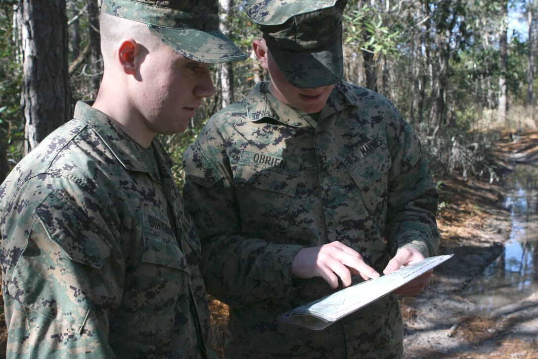 Lance Cpl. Blake Burkhart (left) and Lance Cpl. Jason O’Brien, with 1st Battalion, 6th Marine Regiment, 2nd Marine Division, glance over a map during a land navigation course here, Dec. 3. The Marines trained here in order to keep their field navigational skills sharp and ready for any future deployments.