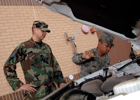 Airman 1st Class Lerma Manuel, 22nd Logistics Readiness Squadron, checks a vehicle’s oil level with the requester, Nov. 14. By checking the oil and other fluid levels the requester gets a vehicle ready to complete mission needs.	 (Photo by Senior Airman Anthony Mejia)