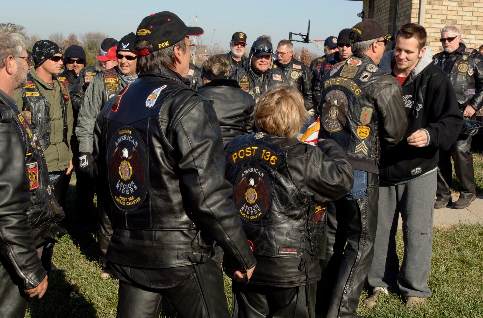 MCCONNELL AIR FORCE BASE, Kan. -- Kansas Patriot Guard members line up to shake hands with Navy Petty Officer 1st Class Christopher Gowen at his home in Derby, Nov. 22. More than 50 Kansas Patriot Guard members came out to honor the explosive ordinance disposal specialist for his service both stateside and while deployed to Iraq.  Petty Officer 1st Class Gowen recently returned home from rehabilitation after suffering serious internal injuries during a deployment as a result of a building explosion.  (Photo by Staff Sgt. Ronald Lafosse)
