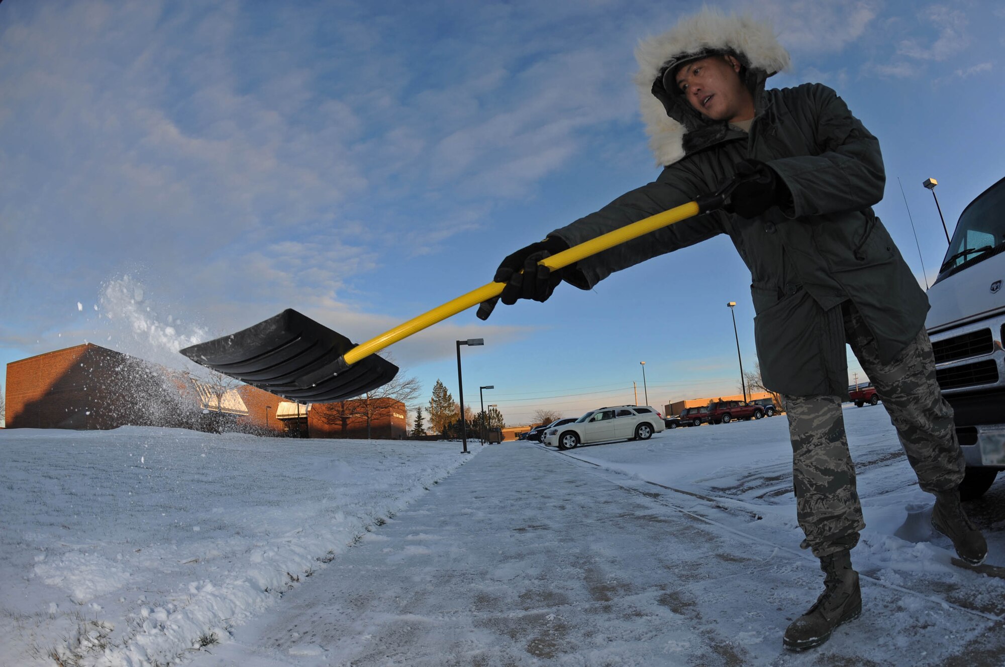 Master Sgt. Jesse Barcega, 28th Force Support Squadron food service supervisor, shovels snow on the sidewalk in front of the Bandit Inn here, Dec. 3. Ellsworth received just under an inch of snow on Dec. 2. (US Air Force photo/Airman Corey Hook)