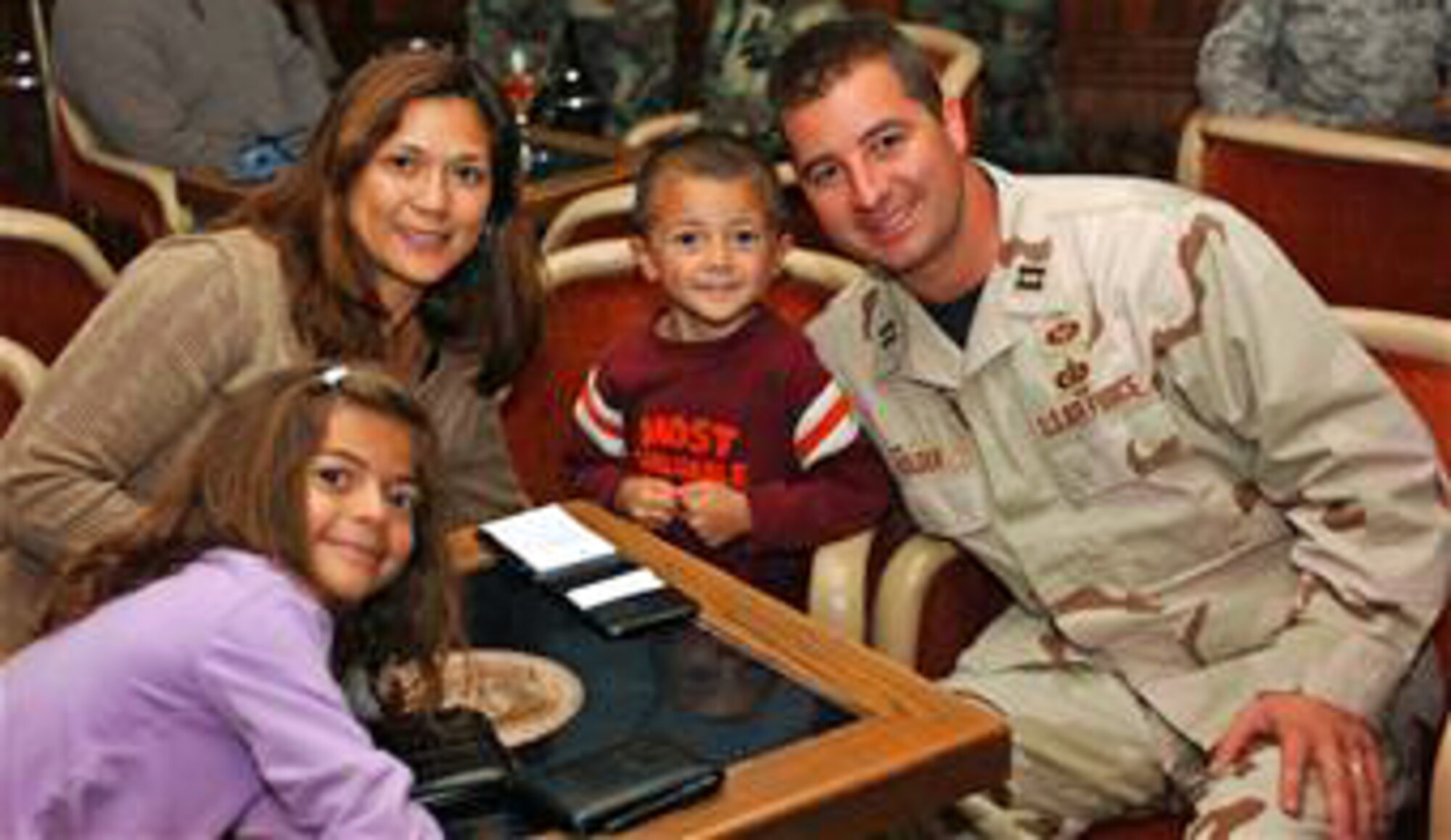 Capt. Jason Holder, his wife, Lydia, and their children Alyssa, 7, and Ethan, 5, celebrate during the Deployed Airmen Welcome Home Dinner at The Club. (U.S. Air Force photo by Lynn Sleeth)  