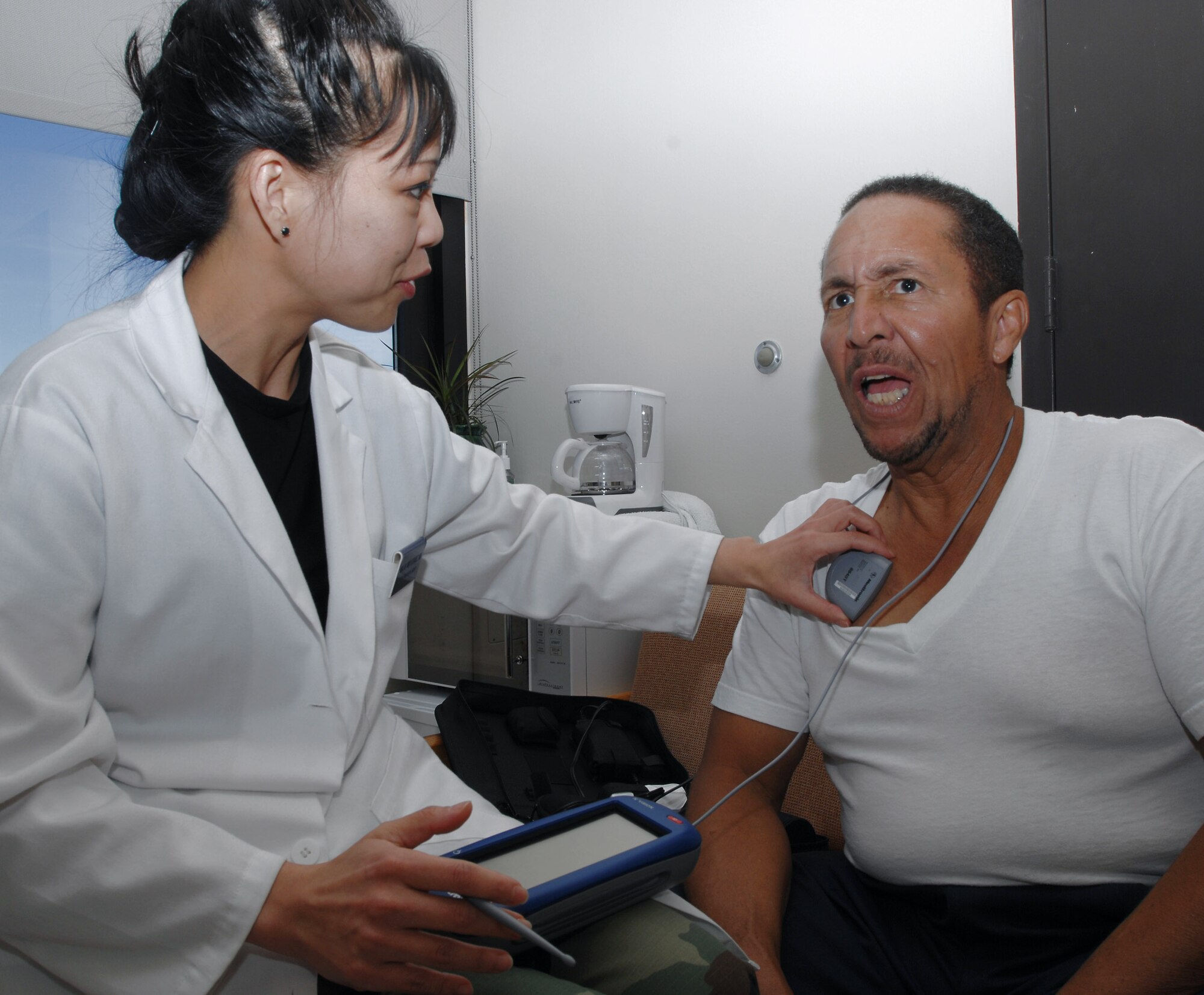 Neurologist Maj. (Dr.) Maria Alvarez adjusts the settings on retired Tech. Sgt. Jewel Yarber's neurostimulator at San Antonio Military Medical Center-South, or Wilford Hall Medical Center Dec. 2 at Lackland Air Force Base, Texas. Sergeant Yarber received a brain stimulator earlier this year which sends electrical impulses to specific parts of his brain to reduce Parkinson's disease symptoms. (U.S. Air Force photo/Senior Airman Robert Barnett)