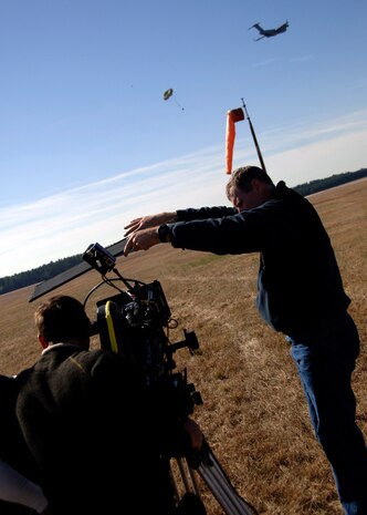 Richard Davidson operates the camera while Geoffrey Herbert deflects unwanted sunlight from the camera's lens during the filming of a live airdrop at Charleston AFB's North Auxiliary Field Nov. 26.Mr. Richard and Mr. Herbert are contracted cameramen from the upcoming movie "Dear John." (U.S. Air Force photo/Senior Airman Timothy Taylor)

