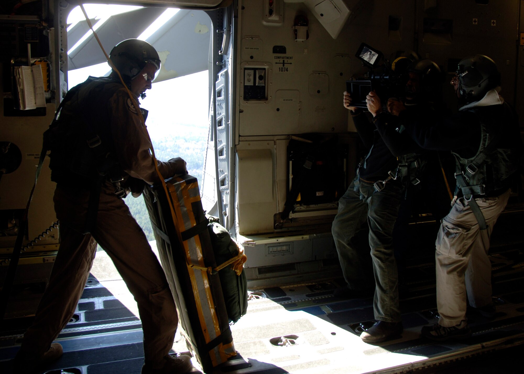 Staff Sgt. Steven Gore prepares to deploy a dummy package from a C-17 over Charleston AFB's North Auxiliary Field while a contracted camera crew films for the upcoming movie "Dear John" films the action Nov. 26. The crew filmed several scenes for the movie in flight, on the flight line and in a Charleston AFB hangar. Sergeant Gore is a loadmaster with the 16th Airlift Squadron. (U.S. Air Force photo/Senior Airman Timothy Taylor)
