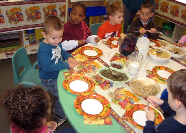 Children from the Preschool 1 classroom prepare to eat during a Thanksgiving feast at the Child Development Center Nov. 20. More than 50 parents joined their children during the lunch. (Courtesy photo)