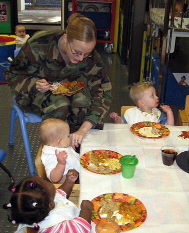 Airman 1st Class Melissa White feeds her daughter, Courtney, during a Thanksgiving feast at the Child Development Center Nov. 20. More than 50 parents joined their children during the lunch. Airman White is with the 437th Airlift Wing Public Affairs Office. (Courtesy photo)