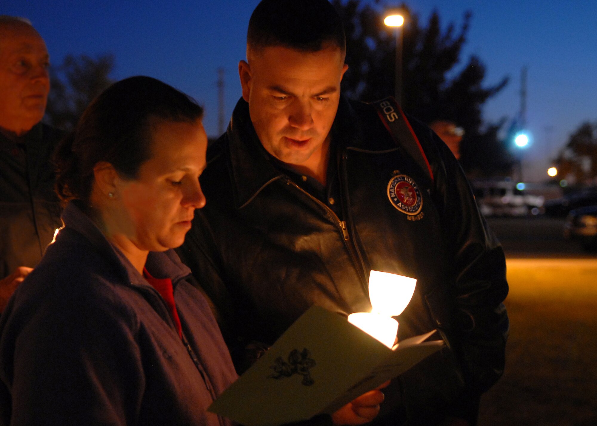 Master Sgt. Thomas Desantis (right), 315th Training Squadron first sergeant, and Senior Master Sgt. Annette Whitenack, 17th Medical Operations Squadron superintendent, sing Christmas carols with others gathered at the annual Goodfellow Air Force Base chapel and tree lighting ceremony on Dec. 1.  This marked the final year that lighting the old chapel would be part of the ceremony as it is due to be demolished in the coming months as chapel services move into a newly constructed building. (U.S. Air Force photo by Senior Airman Kasabyan Musal).