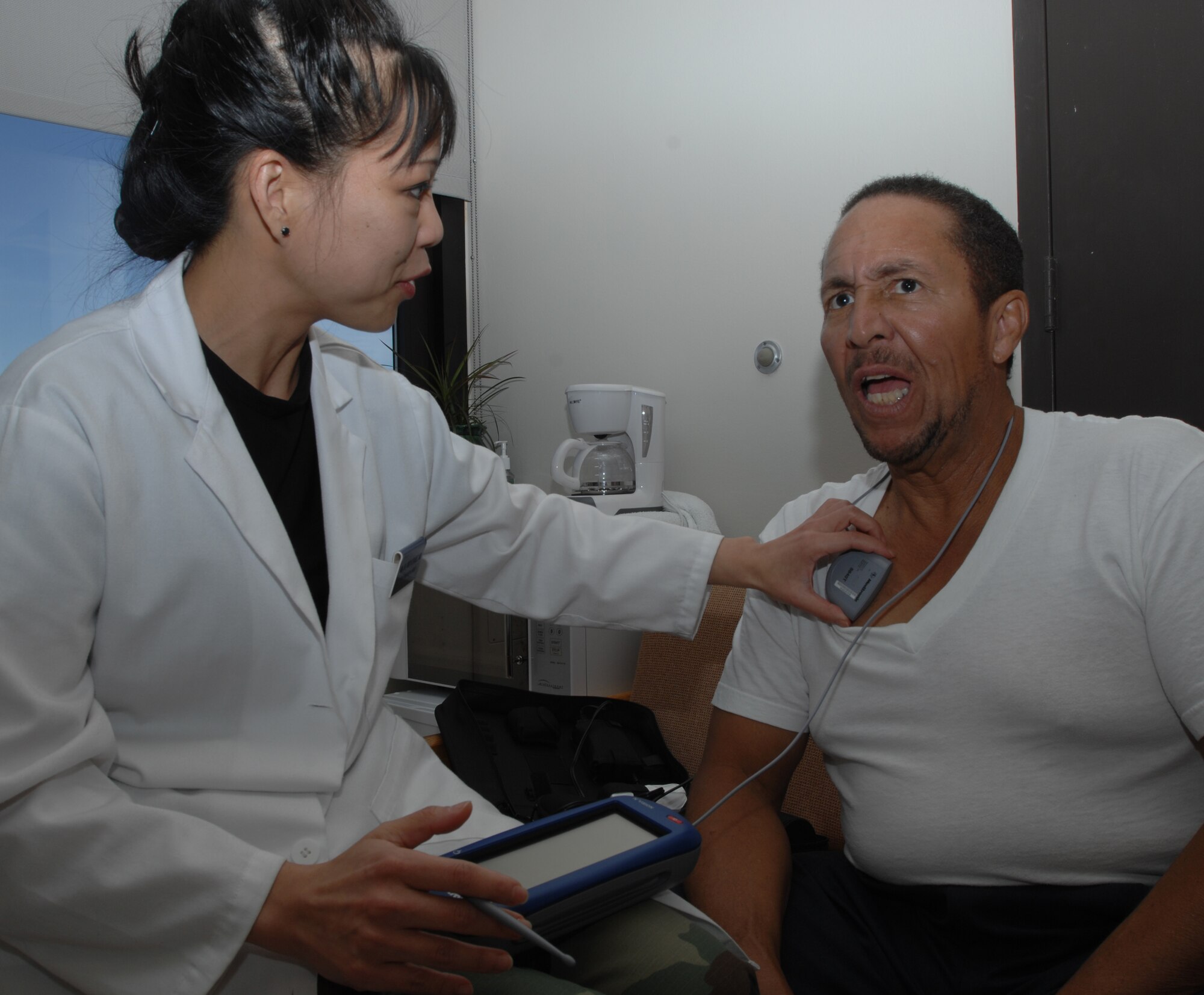Neurologist Maj. (Dr.) Maria Alvarez adjusts the settings on retired Tech. Sgt. Jewel Yarber's neurostimulator at Wilford Hall Medical Center on Dec. 2.  Sergeant Yarber received a brain stimulator earlier this year which sends electrical impulses to specific parts of his brain to reduce Parkinson's disease symptoms.  (U.S. Air Force photo by Senior Airman Robert Barnett)  
