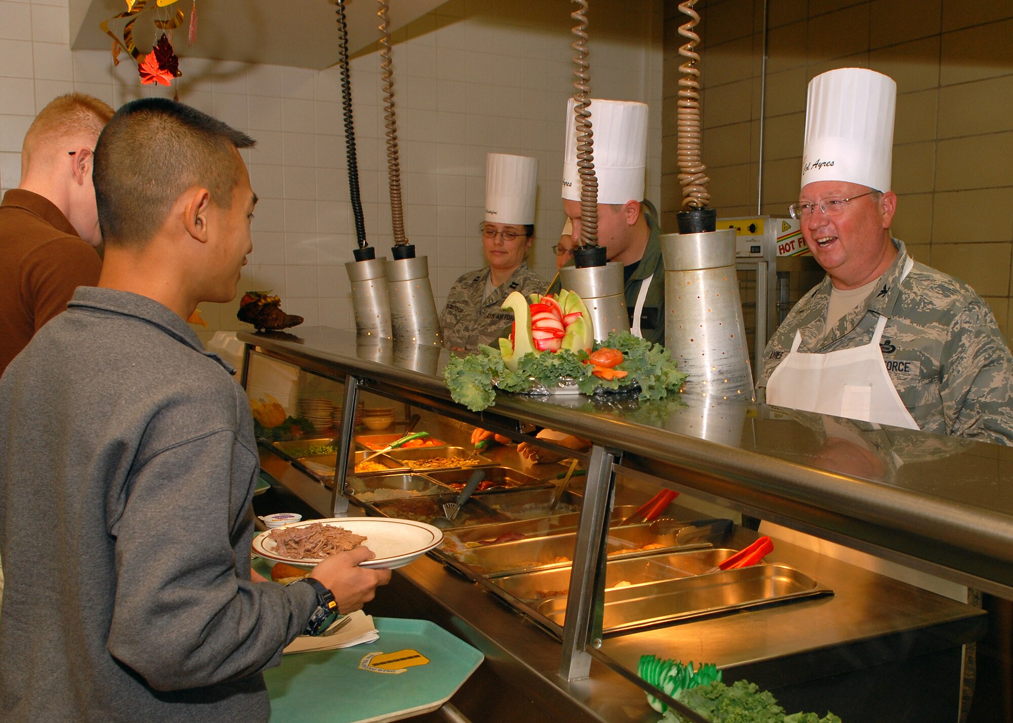 Colonel Richard Ayres (right), 17th Training Wing commander, and other wing leaders serve a traditional Thanksgiving meal to Goodfellow Air Force Base personnel at the Western Winds Dining Facility on Nov. 27.  Each Thanksgiving leadership from the various units on base assists with serving the meal to dorm residents and others who remain on base during the holiday.  (U.S. Air Force photo by Senior Airman Kasabyan Musal).