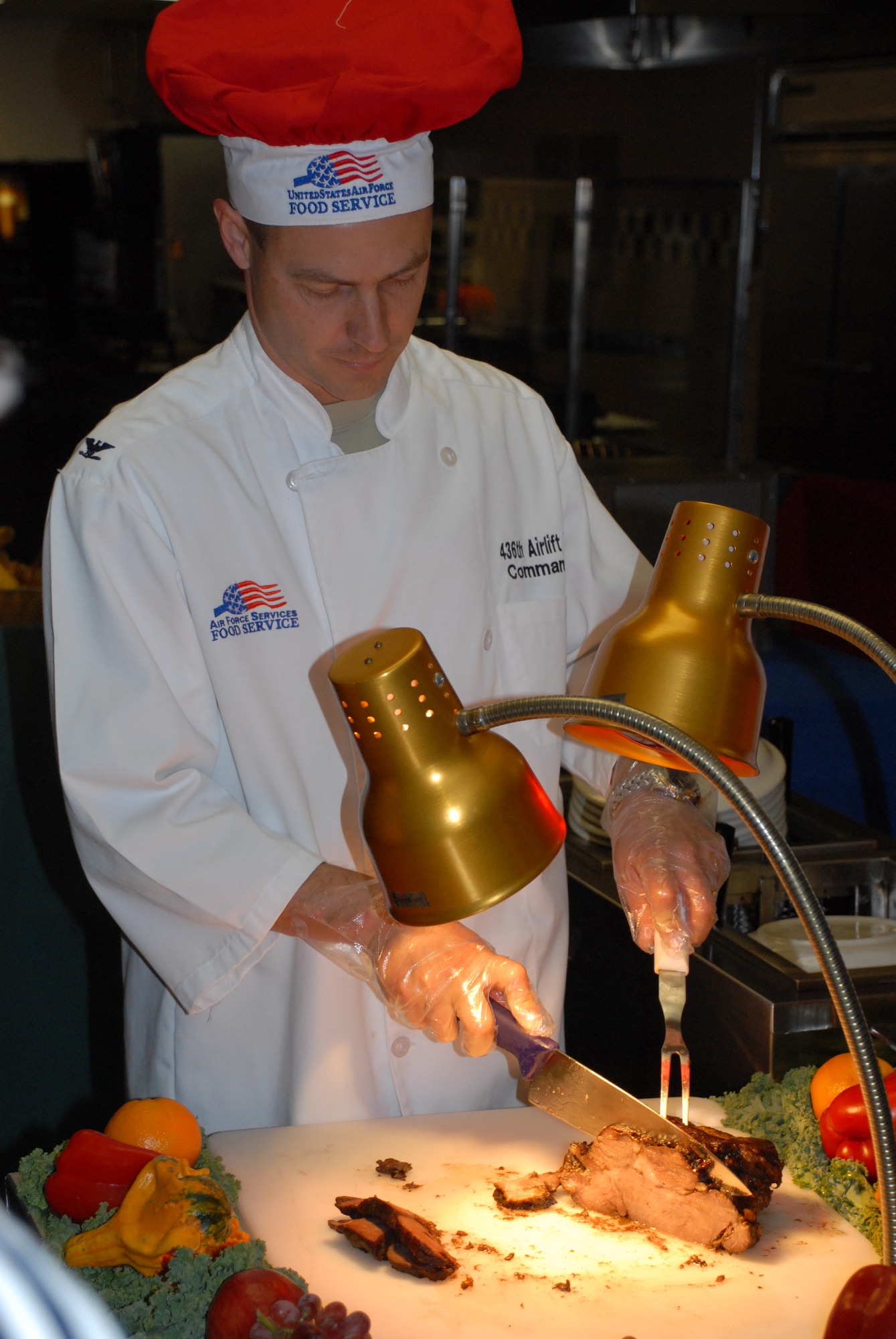 Col. Steven Harrison, 436th Airlift Wing commander, carves a ham for the Thanksgiving feast at the Patterson Dining Facility Nov. 28.  (U.S. Air Force photo/Staff Sgt. Chad Padgett)