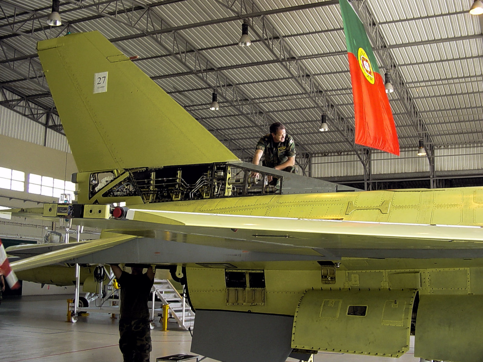 Portuguese air force sergeant Jose Pereira (top), the Dock 4 floor supervisor at Air Base 5 in Monte Real, Portugal, works on an F-16 fighter to ready it for a test flight after going through a mid-life upgrade process.  (Courtesy photo, Manuel Soares)