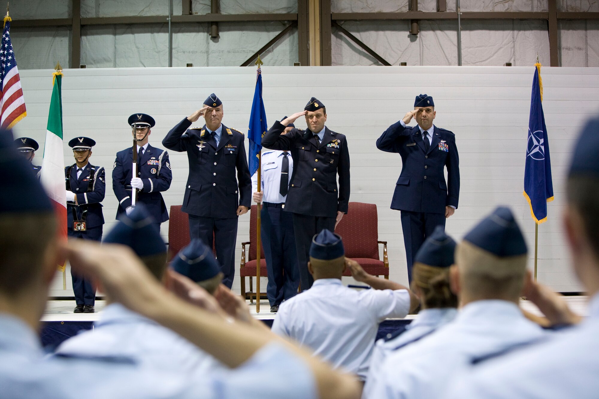 From left to right (center stage), 80th Operations Group Commander Col. Axel Pohlmann, Italian Lt. Col. Vittorio Cencini and Lt. Col. Patrick Testerman honor the United States and Italian flags Dec. 1 during the 89th Flying Training Squadron's change of command ceremony. Colonel Testerman took command of the squadron from Colonel Cencini. (U.S. Air Force photo/Lt. Col. Ternell Washington)