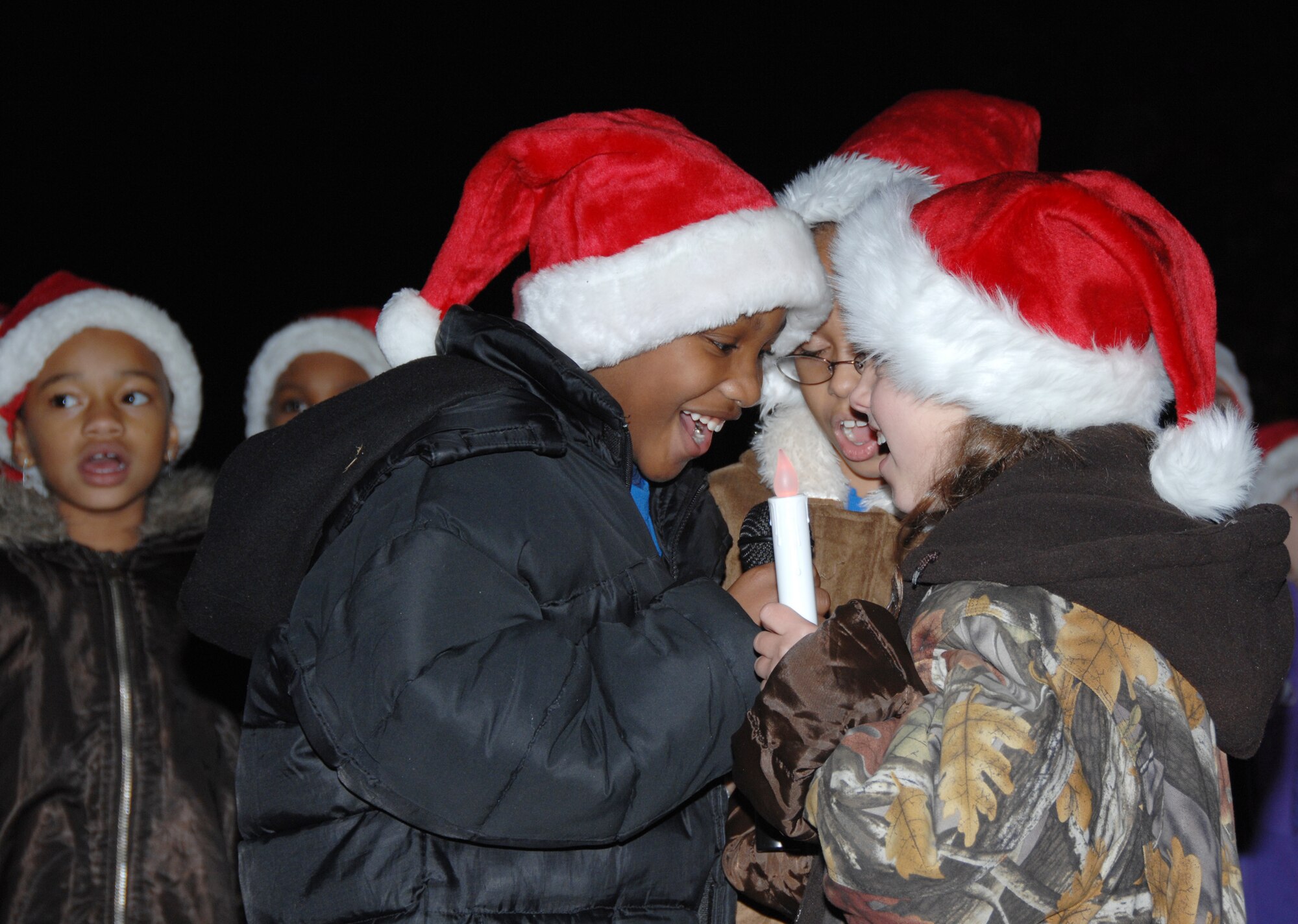 SHAW AIR FORCE BASE, S.C. -- The Shaw Heights Elementary School choir performs for Shaw servicemembers and their families at the annual Team Shaw Christmas Tree Lighting Ceremony here Dec. 2. "This event illustrates what it means to be an Air Force family," said 20th Fighter Wing Chaplain (Lt. Col.) Ronald Underwood. "We can come together for a quality of life event like this from our different specialties and bless the families of our deployed servicemembers. This ceremony brought in the holiday season in a beautiful way." (U.S. Air Force photo/2nd Lt. Emily Chilson)