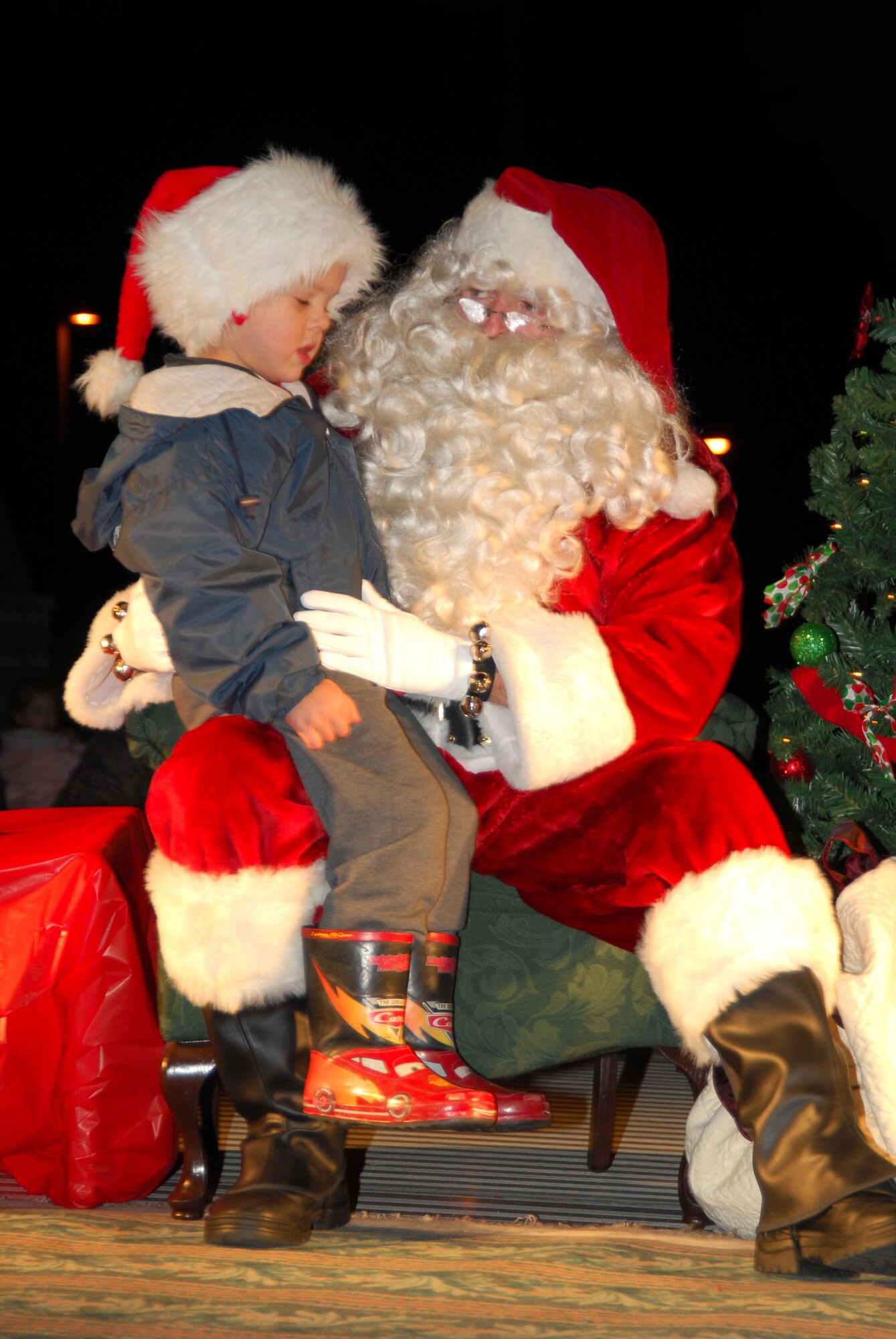 Fulton Ascherl, son of Lt. Col John Ascherl, 1st Air Force Chief of Operations Training, sits on Santa’s lap listing off his desired Christmas yesterday during the base Christmas tree lighting here.  (U.S. Air Force photo by Lisa Norman) 