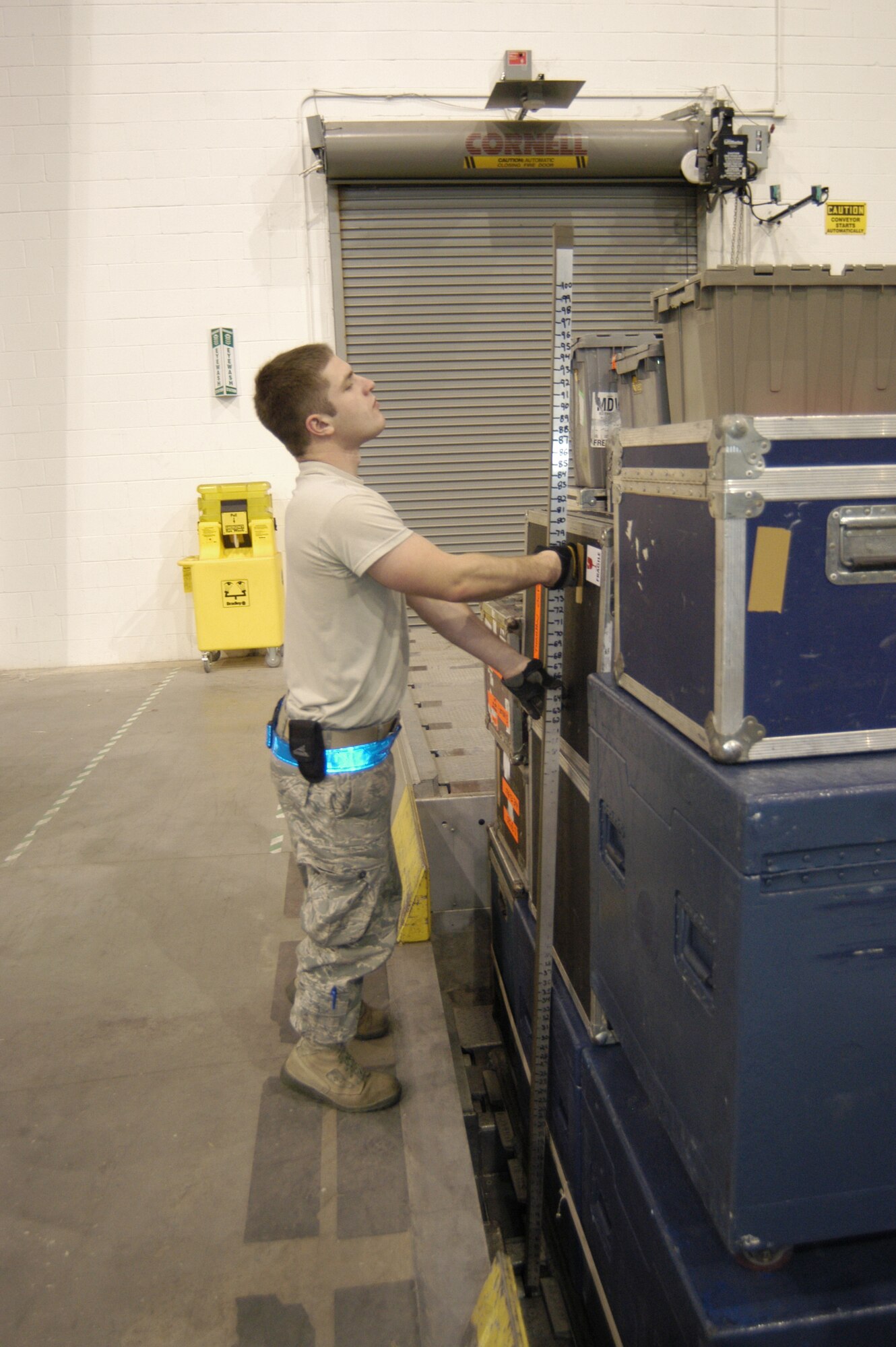 Senior Airman Craig Austin, 436th Aerial Port Squadron cargo processor, checks the height on a pallet filled with equipment from WWE Nov. 30. Porters created several pallets of equipment which accompanied several WWE superstars to Baghdad, Iraq, aboard a Dover C-17. The World Wrestling Entertainment flew to Iraq to put on morale shows for deployed servicemembers. (U.S. Air Force photo/Senior Airman James Bolinger)