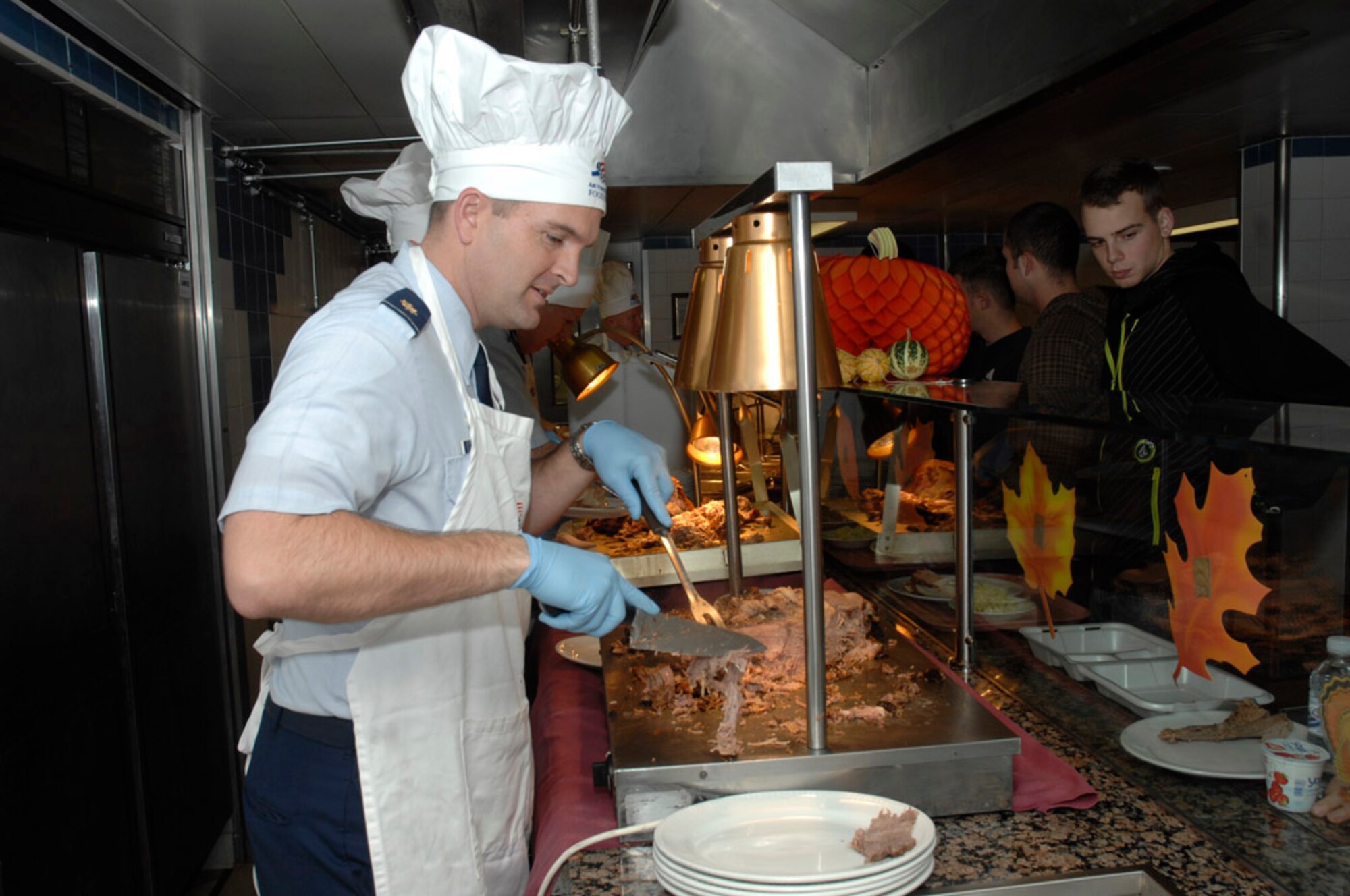 Maj. Sean Murphy, 48th Communications Squadron commander, carves up a turkey to serve to Airmen Nov. 27 at the Knight's Table Dining Facility. Leadership from across the base volunteered their time Thanksgiving Day to bring a taste of home to Liberty Airmen. (U.S. Air Force photo by Senior Master Sgt. Thomas Wood)