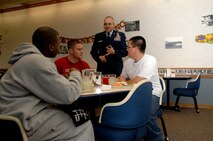 MINOT AIR FORCE BASE, N.D. -- Chief Master Sgt. Mark Clark, 5th Bomb Wing command chief master sgt., talks with a group of Airmen during their Thanksgiving meal presented by the Dakota Inn Dining Facility and unit leaders here. Chief Clark served dessert and mingled with troops to show support for their well-being during the holiday season Nov. 27. (U.S. Air Force photo by Airman 1st Class Benjamin Stratton)