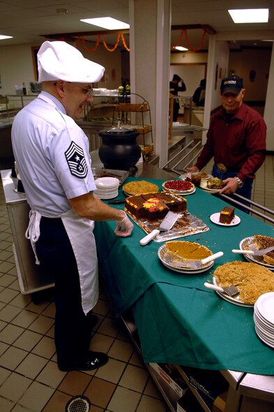 MINOT AIR FORCE BASE, N.D. -- Chief Master Sgt. Mark Clark, 5th Bomb Wing command chief master sgt., serves a piece of chocolate cake to Darrall Lund during the Thanksgiving meal presented by the Dakota Inn Dining Facility and unit leaders here. Chief Clark was one of many leaders who showed their support for Minot's Airmen Nov. 27. (U.S. Air Force photo by Airman 1st Class Benjamin Stratton)