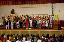 MINOT AIR FORCE BASE, N.D. -- With lemons raised high, North Plains Elementary School 3rd and 4th graders drew the audience in for the finale here. Darcy Klingbeil, their music teacher, brought the kids together to perform a musical entitled, "Lemonade." The musical combined many nursery rhyme stories into one performance. (U.S. Air Force photo by Airman 1st Class Benjamin Stratton)