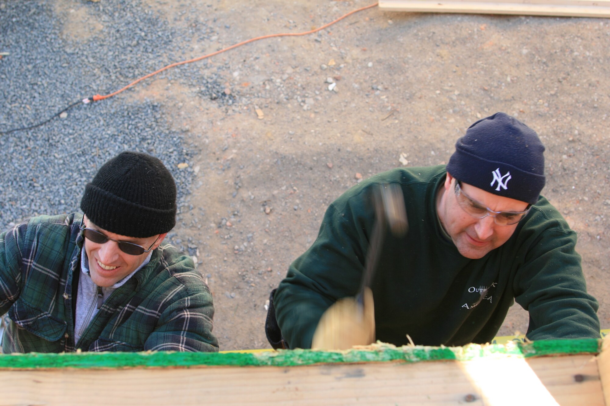 Left, Capt. Jack Schroeder, 305th Communications Squadron deputy commander, and Senior Master Sgt. John O’Donnell, 305th CS Operations Flight superintendent, hang up siding on a house while volunteering with Habitat for Humanity. The 305th CS has been volunteering with Habitat for more than one year. (U.S. Air Force courtesy photo)  