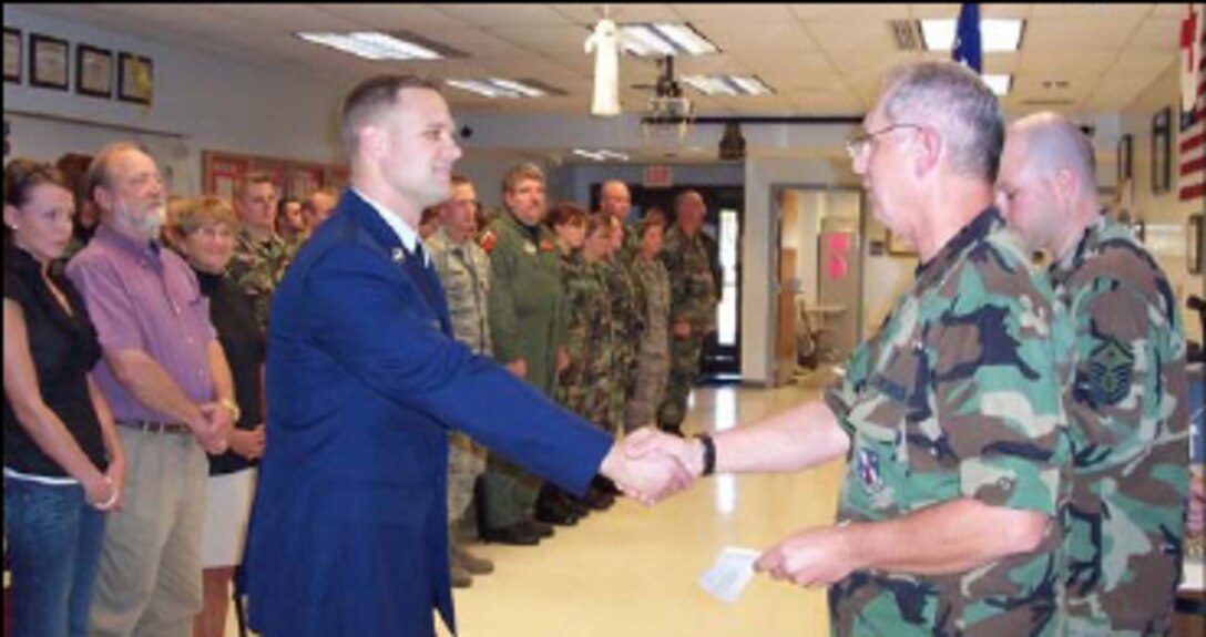 Tech. Sgt. Joshua Carpenter of the 264th Combat Communications Squadron is congratulated by Col. James Baldi shortly after being sworn in as a 2nd Lt. in the 182nd Medical Group October 4, being appointed as a Health Services Administrator. The new lieutenant’s family and members from the 264 CBCS and 182 MDG were in attendance for the occasion. Photo by Maj. Stacie Bourscheidt