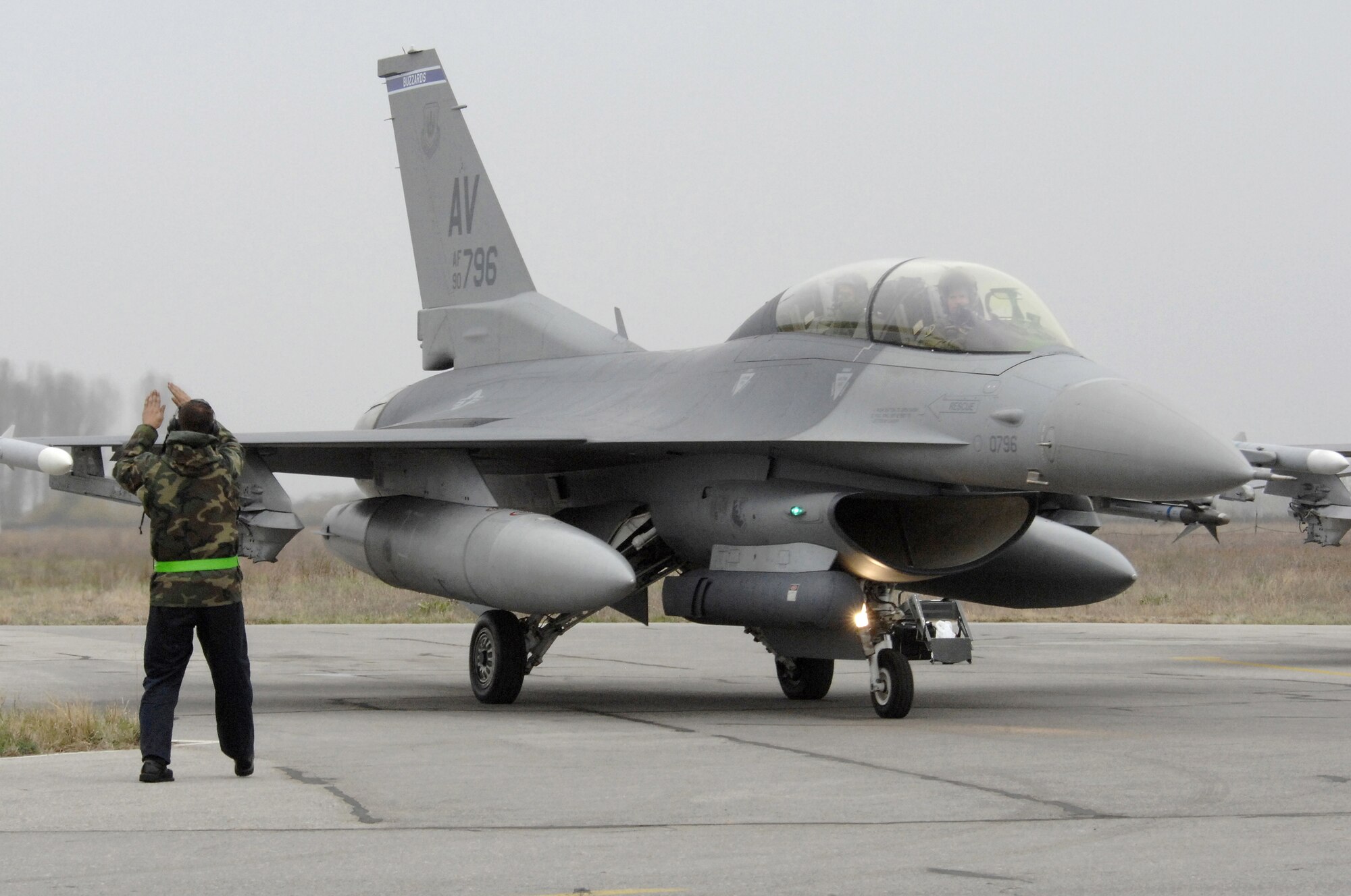 Airmen 1st Class Brian Rowe, 31st Aircraft Maintenance Squadron, marshals an F-16 Fighting Falcon being piloted by Lt. Col. Robert Winkler, commander of the 555th Fighter Squadron, Nov. 7, 2008, at Graf Ignatievo Air Base, Bulgaria.  Colonel Winkler piloted an F-16D sortie with Nancy McEldowney, United States Ambassador to Bulgaria, in the rear seat during the 2008 Nickel Javelin exercise. Nickel Javelin is a 26-day bilateral training exercise between the U.S. and Bulgarian Air Forces. Approximately 250 Airmen from Aviano Air Base participated in the exercise.  (U.S. Air Force photo/Airman 1st Class Ashley Wood)