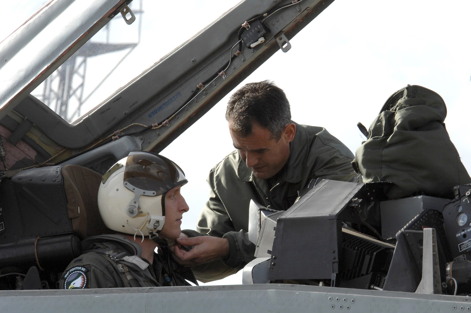 Maj. Nikolay Rusev helps 1st Lt. Craig Baker with his helmet for an incentive ride in a Mig-29 during exercise Nickel Javelin Nov. 10, 2008. Nickel Javelin is a 26-day bilateral training exercise between the U.S. and Bulgarian Air Forces. (U.S. Air Force photo/Airman 1st Class Ashley Wood)