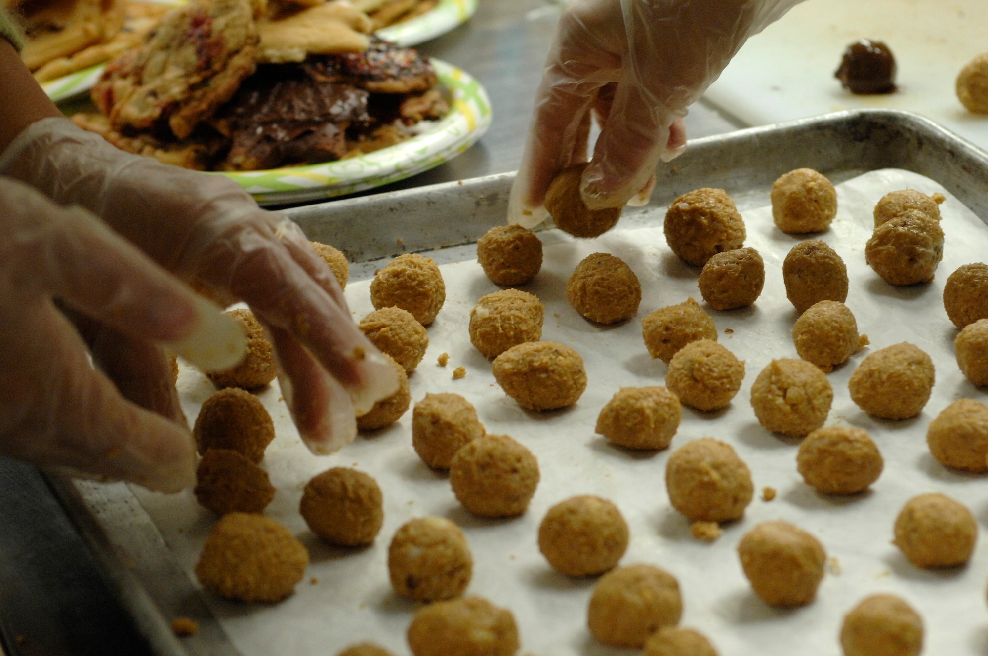 Shawn Stevens and Rosanna Riondato ball up cookie dough to put in the oven during the Airman Cookie Drive at the La Bella Vista club Dec. 2.  This year’s cookie drive was co-hosted by the Aviano Officers and Civilians Spouses Club and the Aviano Community Enlisted Spouses Club. (U.S. Air Force photo/Airman 1st Class Ashley Wood)