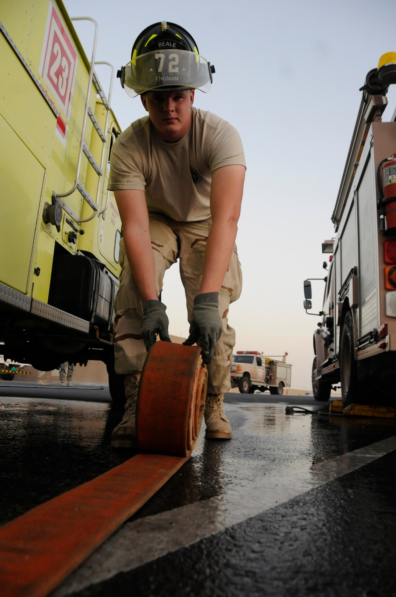Senior Airman Chad Engman, a firefighter assigned to the 379th Expeditionary Civil Engineer Squadron, rolls a fire hose to ensure all the water is drained following a fire training exercise Dec. 1, at an undisclosed air base in Southwest Asia. Firefighters here train daily to ensure they are prepared should disaster strike.  Airman Engman, a native of Cincinnati, Ohio, is deployed from Beale AFB, Calif., in support of Operations Iraqi and Enduring Freedom and Joint Task Force-Horn of Africa. (U.S. Air Force photo by Staff Sgt. Darnell T. Cannady/Released)