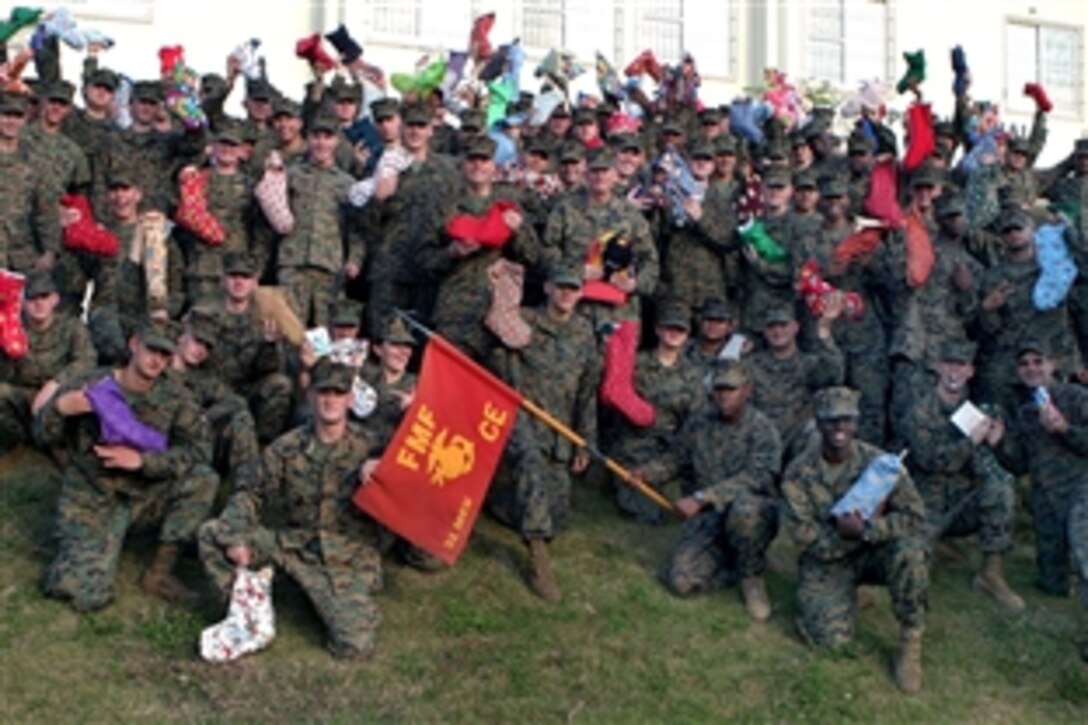 U.S. Marines and sailors assigned to the 31st Marine Expeditionary Unit raise Christmas stockings donated by the Central Illinois Proud Families of Marines for Operation Santa USMC on Camp Hansen, Okinawa, Japan, Dec. 1, 2008. 