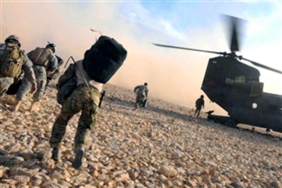 U.S. and Coalition Forces rush to board an CH-47 Chinook helicopter during Task Force Eagle Assault after it lands on a base in southern Afghanistan, Nov. 29, 2008.