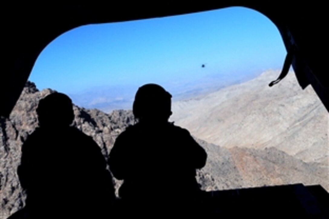 Two U.S. Army UH-47 Chinook helicopter crew members scan the craggy peaks of a mountain range during a mission over Afghanistan, Nov. 28, 2008. The soldiers serve as a part of Task Force Eagle Assault, which patrols the skies over 20 to 30 percent of Afghanistan.