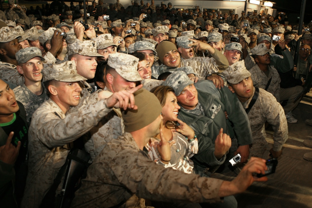 World Wrestling Entertainment diva Mickie James poses with Marines aboard Camp Ramadi, Iraq during the sixth annual “Tribute to the Troops” tour, Dec. 3. James was joined by 5 other WWE superstars and spent the evening signing autographs and posing for pictures.