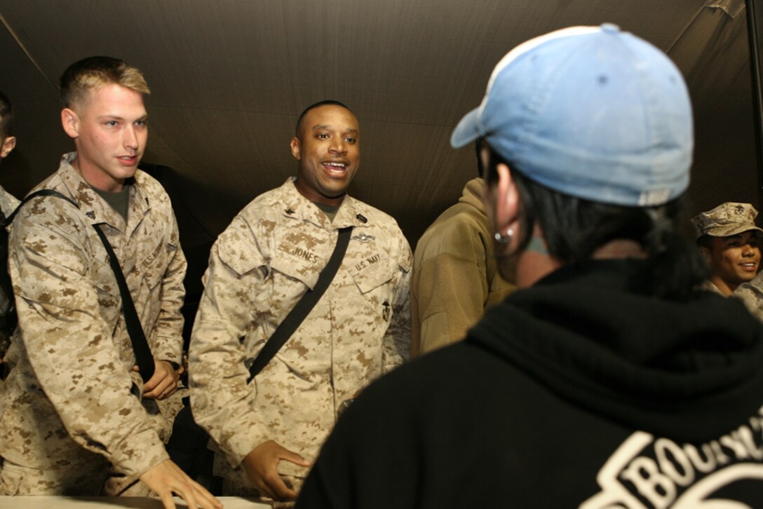 Cpl. Jacob D. Chadwick (left), an administrative clerk, and Petty Officer 3rd Class Terrance R. Jones, a corpsman, both with Regimental Combat Team 1, get autographs from World Wrestling Entertainment superstar Philip “CM Punk” Brooks during the “Tribute to the Troops” tour aboard Camp Ramadi, Iraq, Dec. 3.