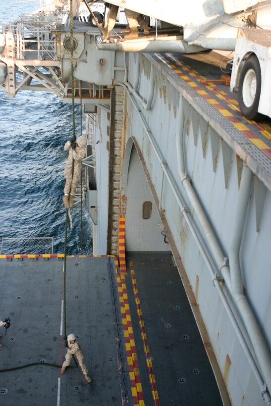 Marines with the 26th Marine Expeditionary Unit fast-rope out of the back of a CH-46E Sea Knight helicopter aboard USS Iwo Jima, Dec. 04, 2008. Reconnaissance Marines with the MEU's Command Element conducted the sustainment training and invited other CE sections to participate to maintain their own proficiency. The 26th MEU and Iwo Jima Strike Group are currently deployed to the 5th Fleet area of operation.