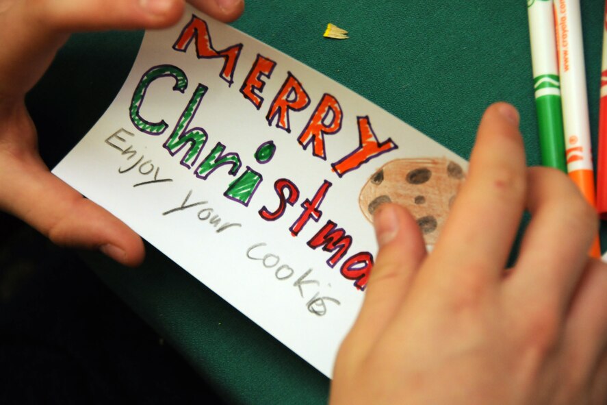 MISAWA AIR BASE, Japan -- Kaleb Miller, high school volunteer, finishes a holiday card during the 35th Fighter Wing Cookie Caper Dec. 3, 2008. Each wrapped tray of cookies was topped with a holiday card, which was designed by children of Misawa Air Base's public schools. (U.S. Air Force photo by Senior Airman Jamal D. Sutter)