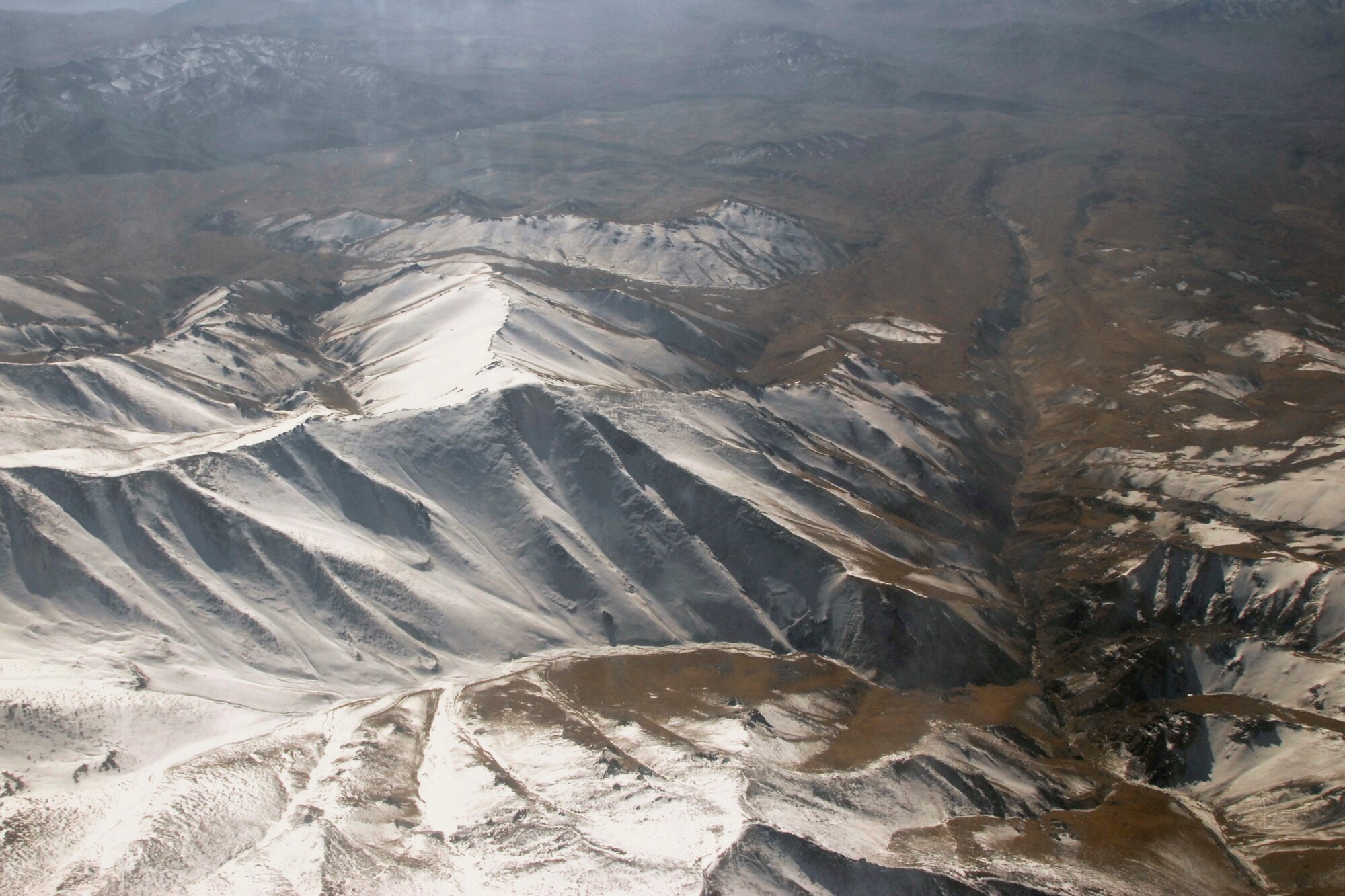 Loadmasters Master Sgt. Josh Meister and Tech. Sgt. Jason Weber, both with the 109th Airlift Squadron, 133rd Airlift Wing, see mountainous terrain in Afghanistan while scanning for threats on the way to Herat, Afghanistan Monday Dec. 1, 2008.  