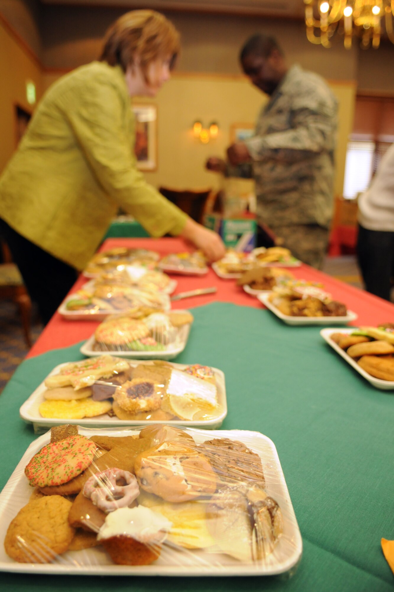 MISAWA AIR BASE, Japan -- Julia Bancroft, wife of John Bancroft, 35th Operations Support Squadron, and Tech. Sgt. Ronald Griffith, 35th Logistics Readiness Squadron non-commissioned officer in charge of vehicle management and analysis, wrap trays of cookies during the 35th Fighter Wing Cookie Caper Dec. 3, 2008. More than 15,500 cookies were donated by the community in support of the event. (U.S. Air Force photo by Senior Airman Jamal D. Sutter.)