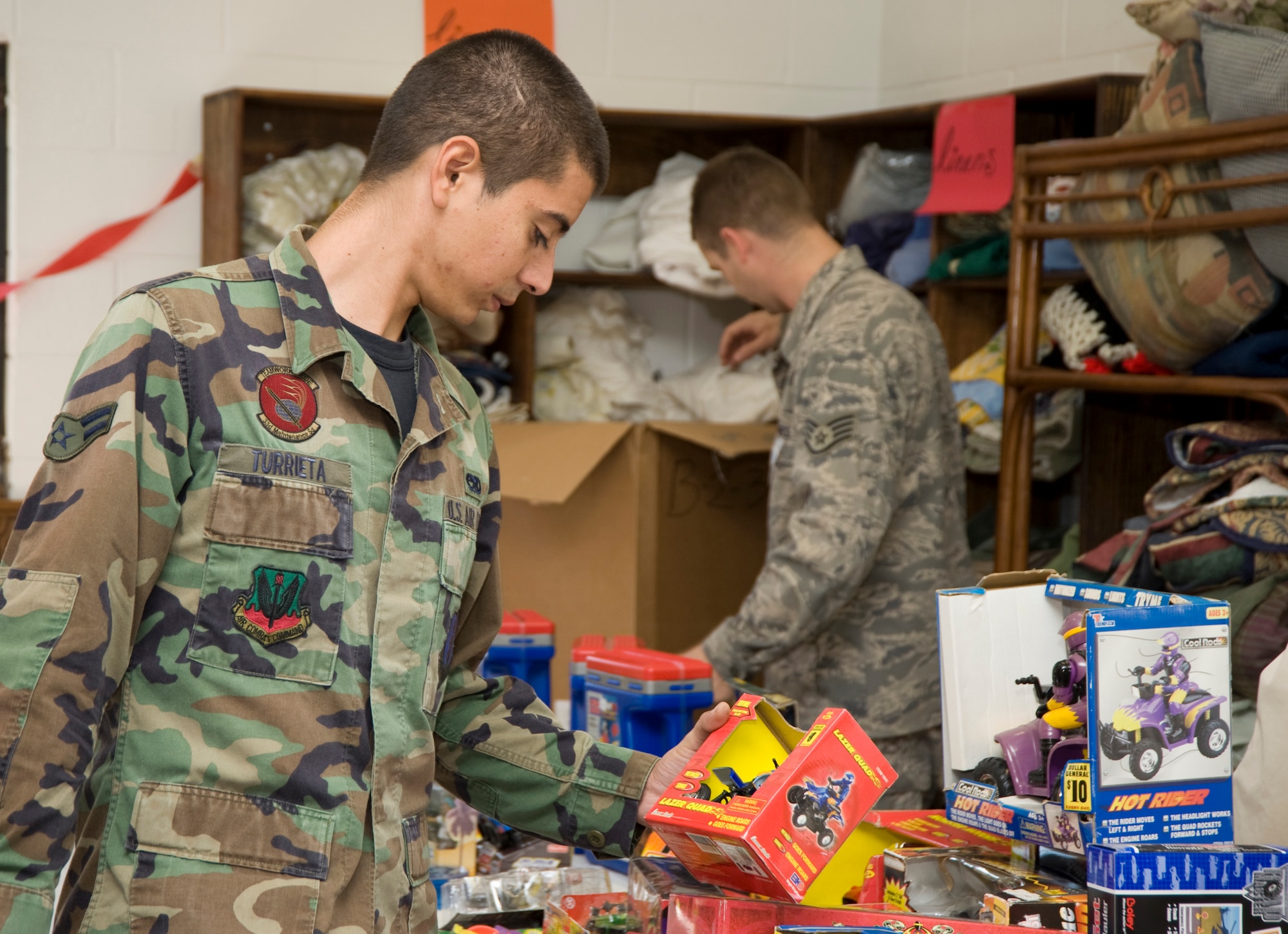 EGLIN AIR FORCE BASE, Fla. -- Airman Michael Turrietta, 33rd Maintenance Squadron, rummages through the piles of toys, puzzles, baby dolls and games to find the perfect gift during the Toys-for-Tots distribution at the Airman's Attic Dec. 2. (Courtesy Photo)