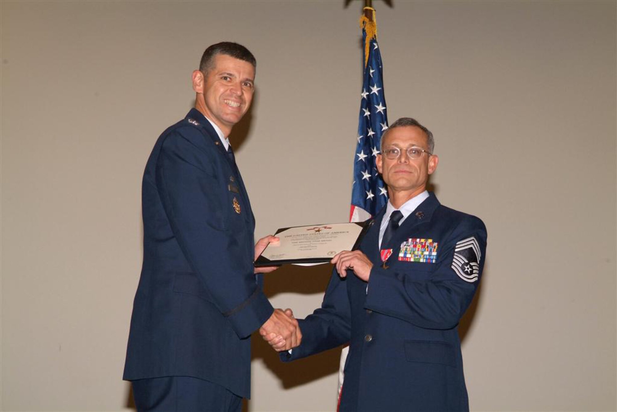 Col. Jose A. Rivera (left), 5th Combat Communications Group commander, presents the Bronze Star citation to Chief Master Sgt. Thomas Perry, a member of the 53rd Combat Communications Squadron. U.S. Air Force photo by Tommie Horton
