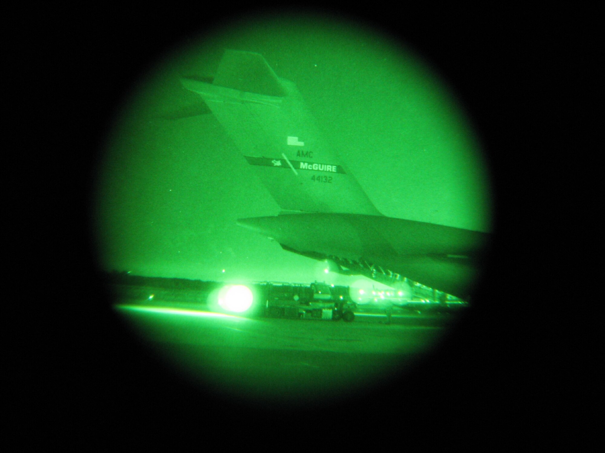 An 817th Contingency Response Group Airman positions a Next Generation Small Loader to load cargo onto a C-17 Globemaster from McGuire Air Force Base, N.J. in near blackout conditions. The cargo loading was part of a Joint Task Force Port Opening exercise that took place at Lakehurst Naval Air Engineering Station, N.J., Dec. 1-3.