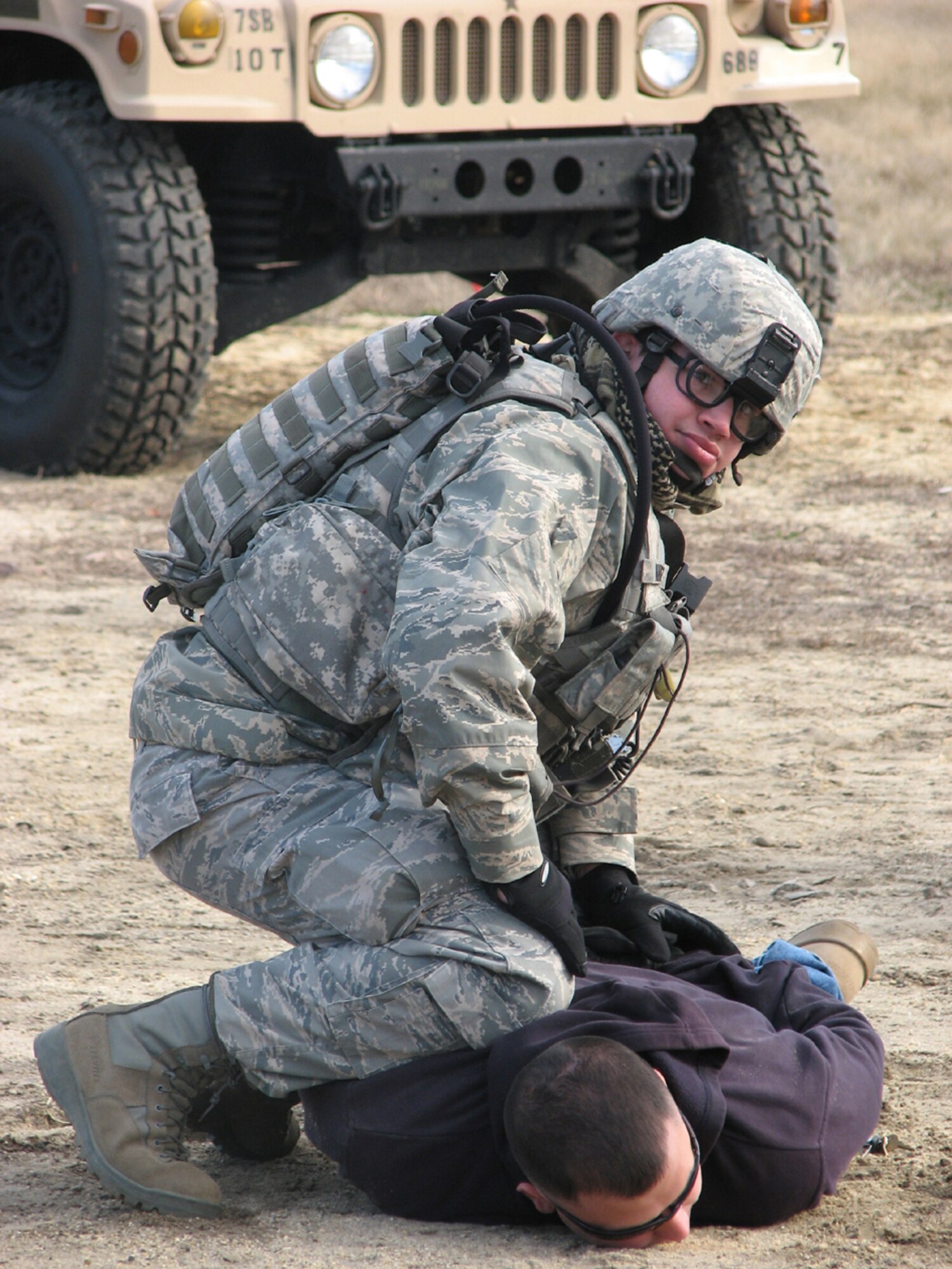 Senior Airman Joshua Ramirez, 817th Contingency Response Group force protection, subdues a simulated "gate crasher" during a scenario for a Joint Task Force Port Opening exercise held at Lakehurst Naval Air Engineering Station, N.J., December 1-3. JTF-PO is an expeditionary capability in which Air Force and Army elements work together to rapidly extend a distribution network. (U.S. Air Force photo/1st Lt. Dustin Doyle)