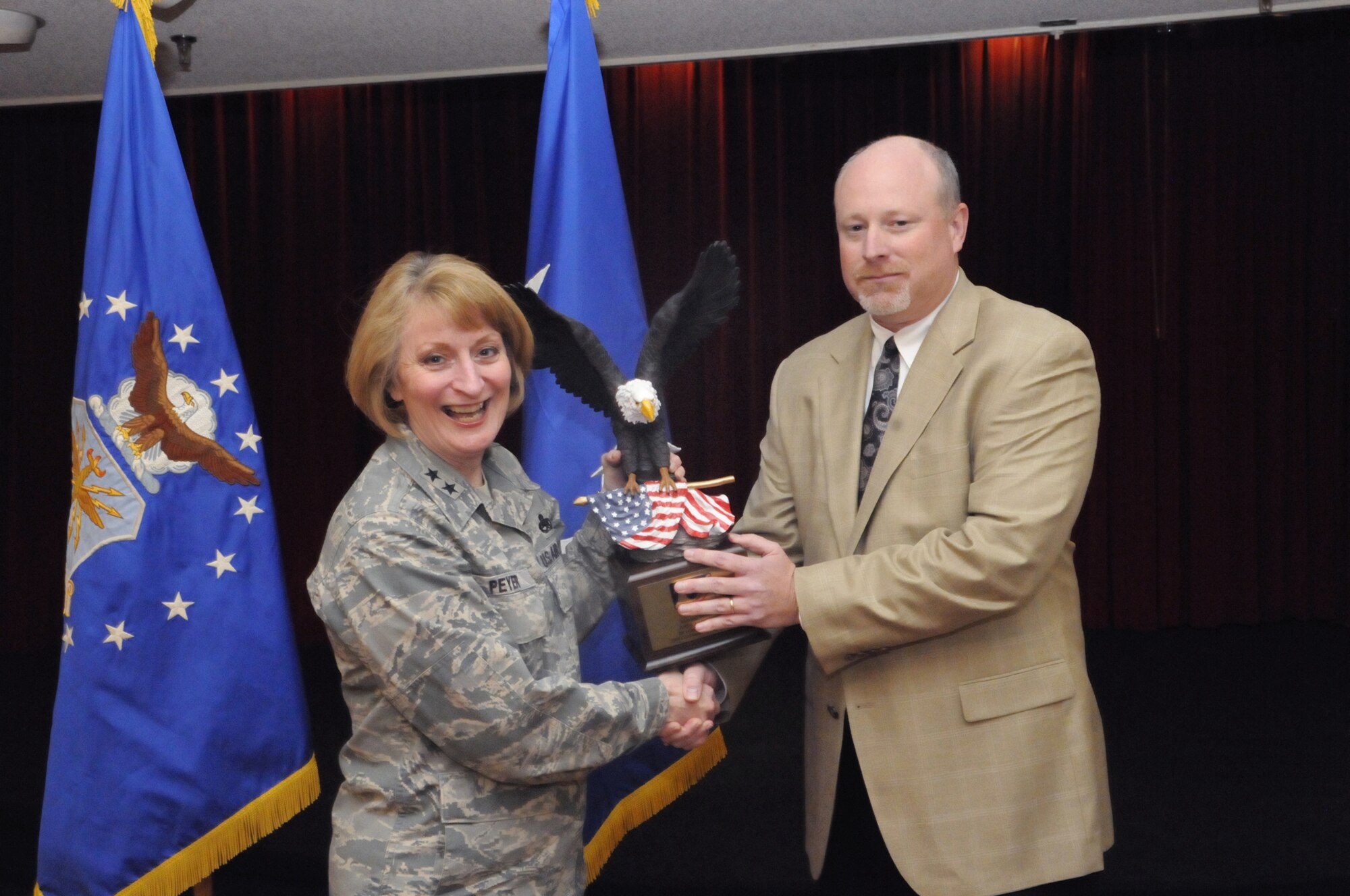 Maj. Gen. Polly Peyer, Warner Robins Air Logistics Center commander, accepts an eagle trophy to the men and women at Robins from Brian Vassey, 2008 CFC chairman, for making and exceeding this year's goal. U. S. Air Force photo by Sue Sapp