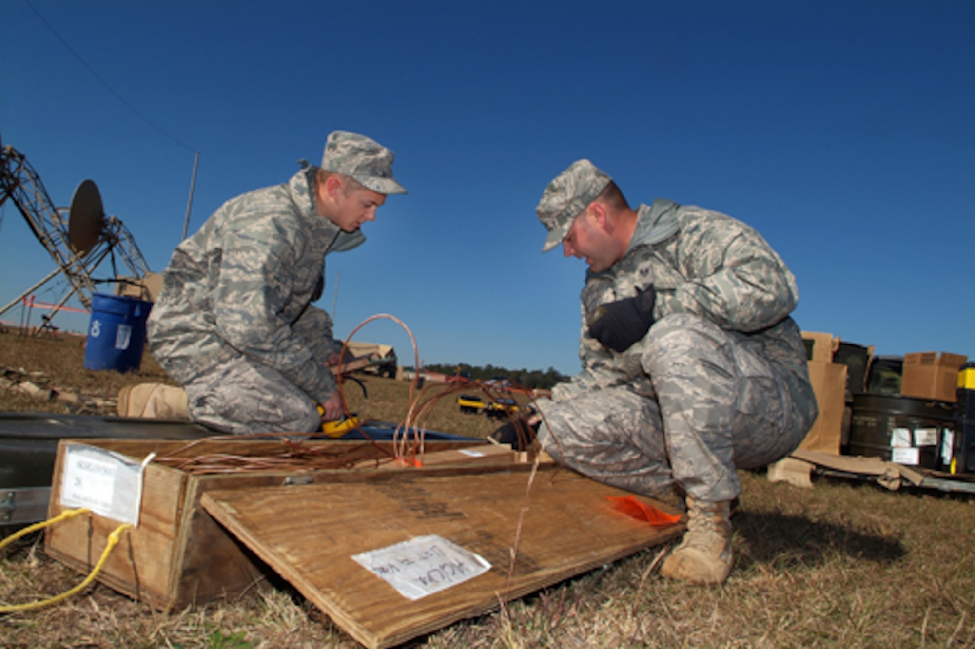 Airman 1st Class David Hunstberger and Staff Sgt. Trent Lundell, both with the 54th CBCS, open a grounding kit used to protect equipment from electrical damage. U.S. Air Force photo by Tommie Horton