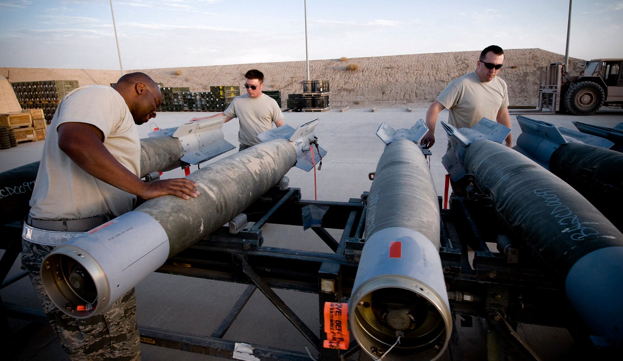 Airmen of the 451st Air Expeditionary Group Logistics Flight-Ammo checks guided bomb unit-12 laser-guided bombs Oct. 27 at Kandahar Airfield, Afghanistan. The three-man team frequently handles munitions separately, but some tasks require all three Airmen to work together to get the job done. (U.S. Air Force photo/Staff Sgt. Samuel Morse) 

