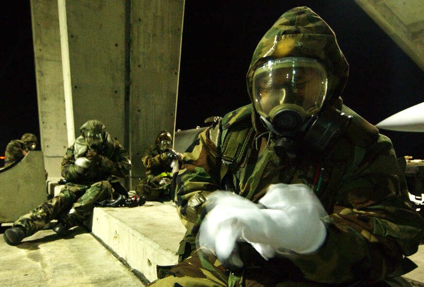 Senior Airman Luis Gregorio and other Airmen from the 44th Aircraft Maintenance Unit don their chemical protective overgarments prior to an attack Dec. 4, during Local Operational Readiness Exercise Beverly High 09-01 at Kadena Air Base, Japan. The 18th Wing is conducting the exercise to test the readiness of Kadena Airmen. (U.S. Air Force photo/Tech. Sgt. Rey Ramon) 
