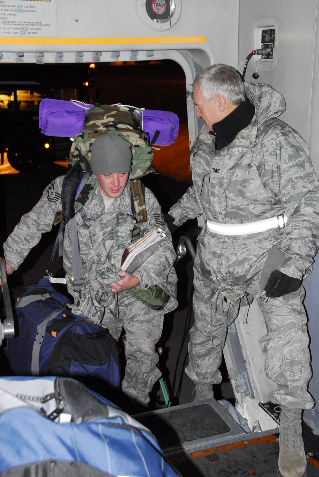 U.S. Air Force Col. Mark Johnson, 148th Fighter Wing Commander, (right) helps guardsmen as they load a C17 Globemaster in Duluth, Minn. Dec. 3, 2008.  148th Fighter Wing members are deploying to Joint Base Balad, Iraq as a part of an Air Expeditionary Force (AEF) deployment. (U.S. Air Force photo by TSgt Jason W. Rolfe) (Released)