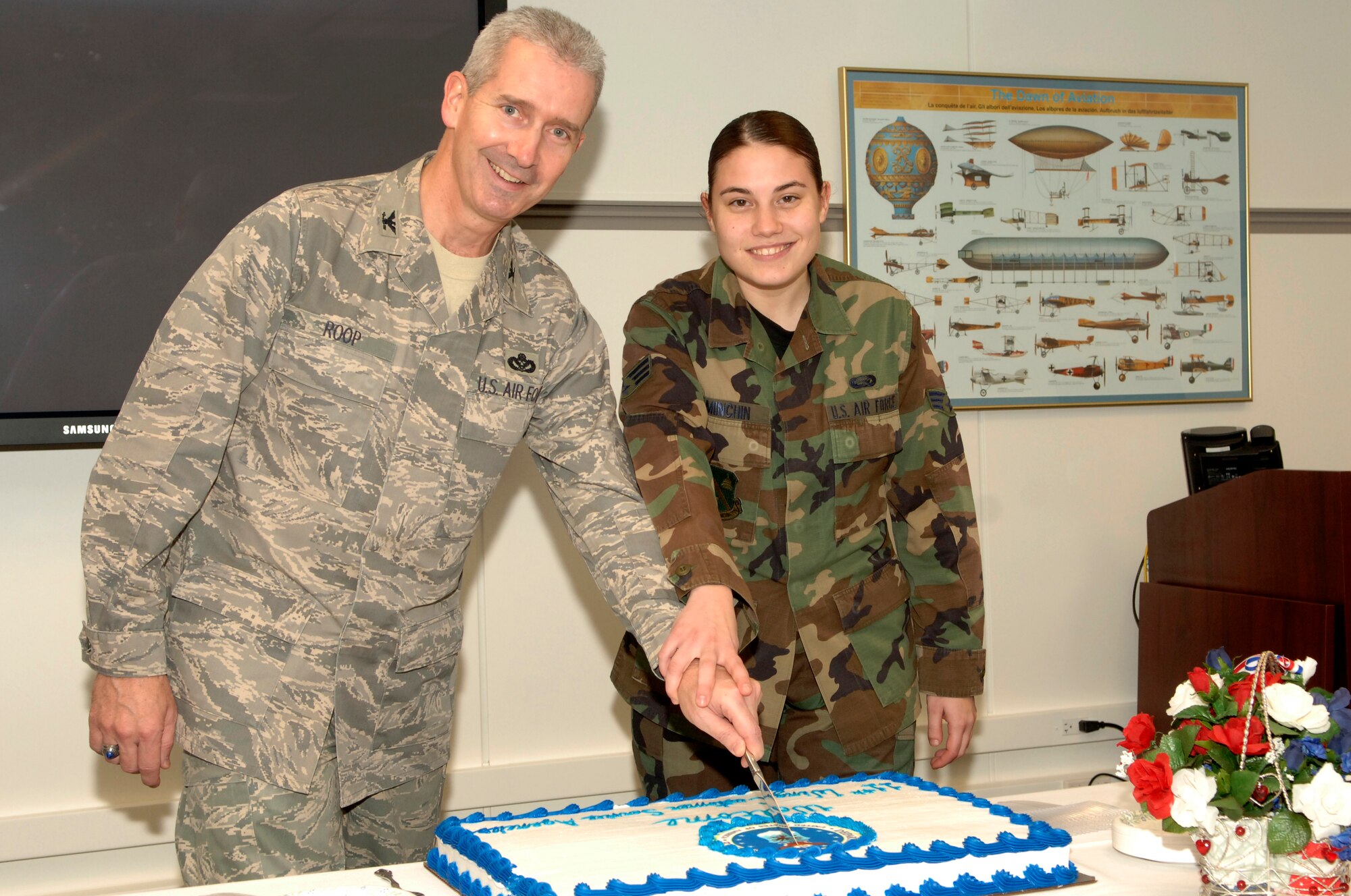 Col. Jon A. Roop, 11th Wing commander and Senior Airman Jessica Minchin, 11th Mission Support Squadron, cut cake for the opening of the new co-located Pentagon Military Personnel Flight, Airman and Family Readiness Center, Military Testing and Finance Offices, Dec. 2. The co-located offices will provide better customer service to more than 55,000 military members assigned to the Pentagon. (US Air Force photo by Mr. Thomas Dennis)