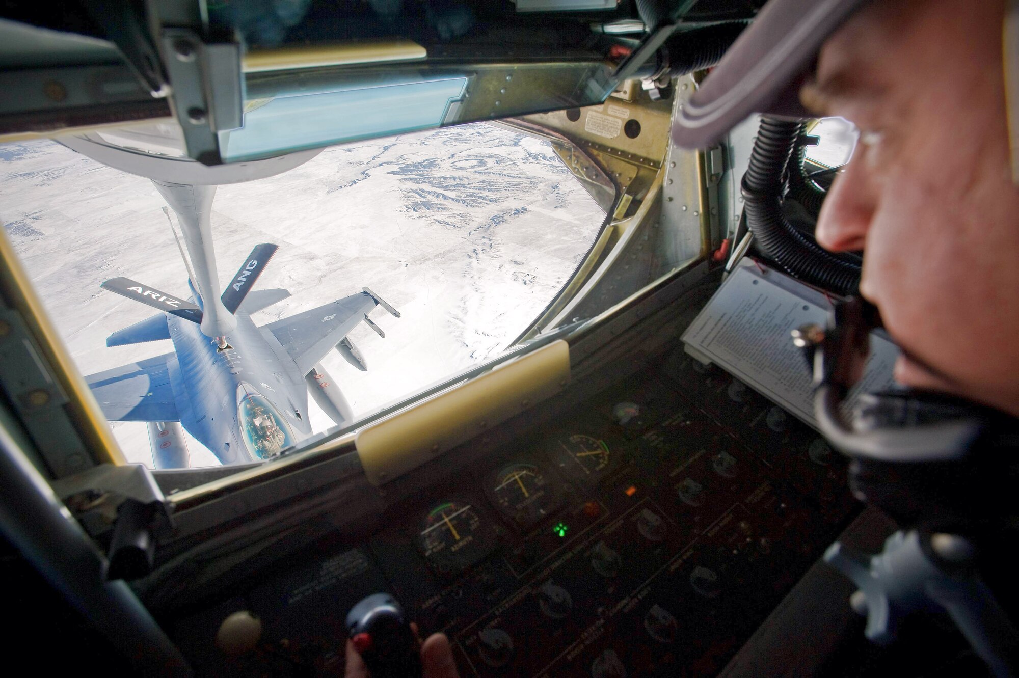 Master Sgt. Jeffrey Madorski refuels an F-16 Fighting Falcon from a KC-135 Stratotanker Dec. 1 over the Southwestern United States. The F-16 was en route to Barksdale Air Force Base, La., to take part in Green Flag East, a pre-deployment exercise for Air Combat Command flying units that perform close-air support and precision-guided munitions delivery. Sergeant Madorski is a KC-135 boom operator with the 161st Air Refueling Wing with the Arizona Air National Guard. The F-16 is from the 120th Fighter Squadron of the Colorado Air National Guard. (U.S. Air Force photo/Master Sgt. John Nimmo Sr.)